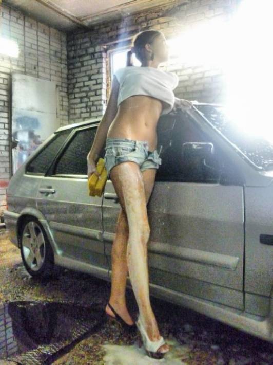Красивая девушка моет автомобиль